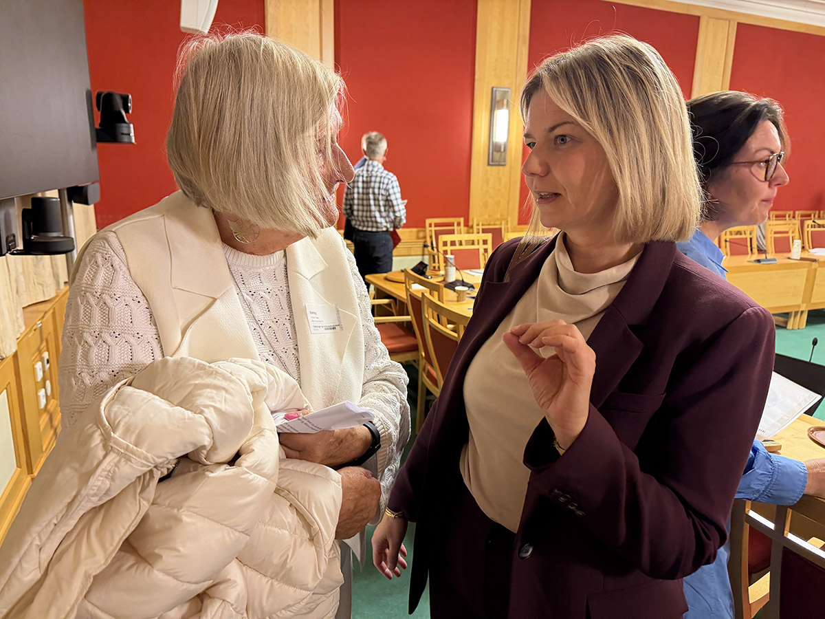 Helga Arntzen i samtale med Guri Melby i komitérommet