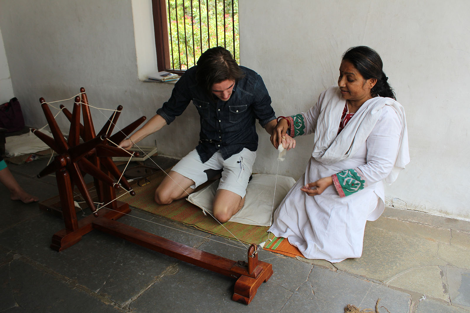Deltaker prøver tradisjonell spinning ved Gandhi Ashram i Ahmedabad